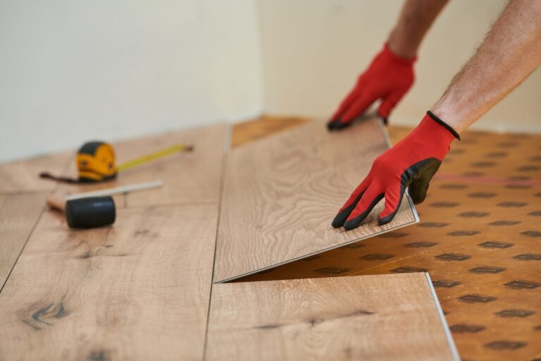 vinyl flooring. Worker installing planks with under laying at home flooring renovation.